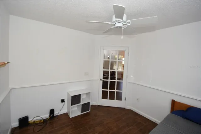 a view of a hallway with wooden floor and a bathroom