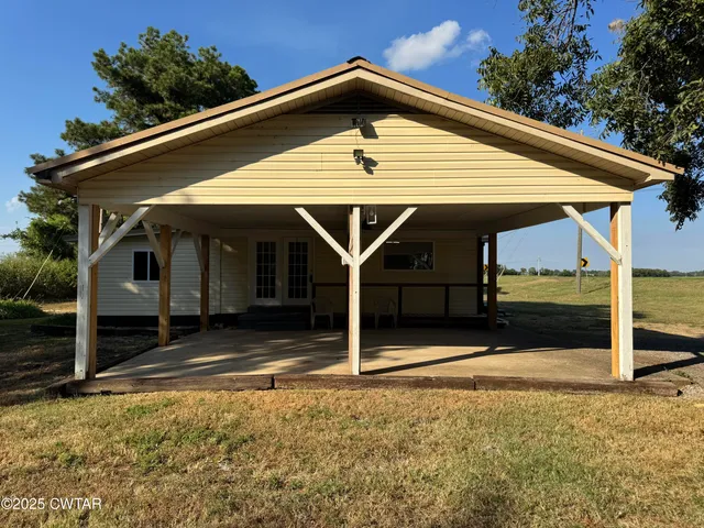 a view of house with parking space and yard
