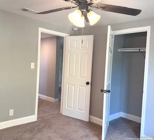 a view of a hallway with a chandelier fan