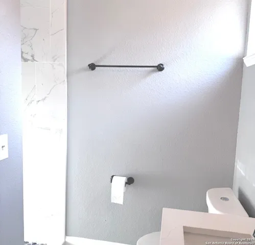 a bathroom with a toilet and a shower