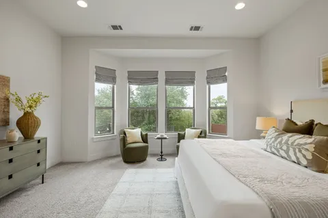 a bedroom with a bed and large windows