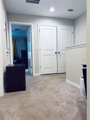 an empty room with closet and mirror
