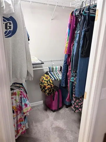 a view of walk in closet with clothes and shoes