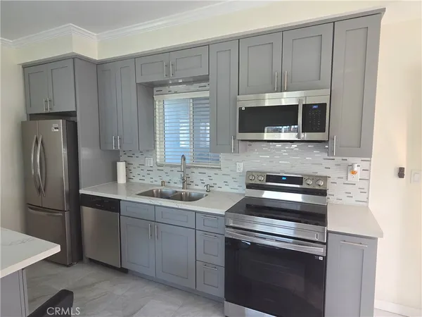 a kitchen with stainless steel appliances a stove microwave and sink
