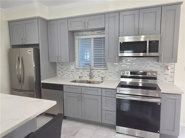 a kitchen with stainless steel appliances a stove microwave and refrigerator