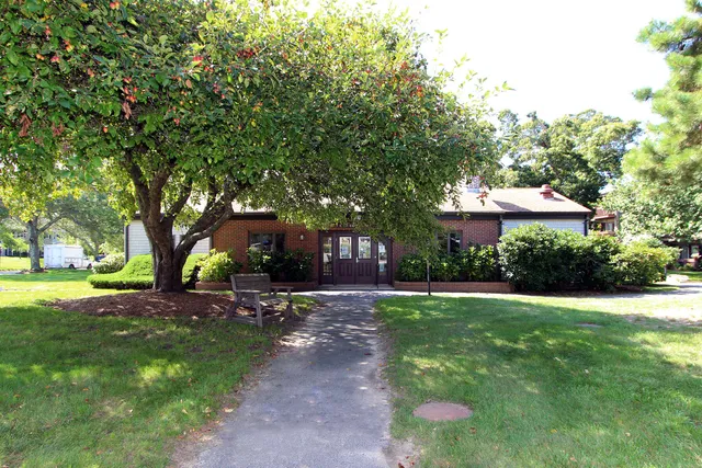 a view of a house with a yard and sitting area