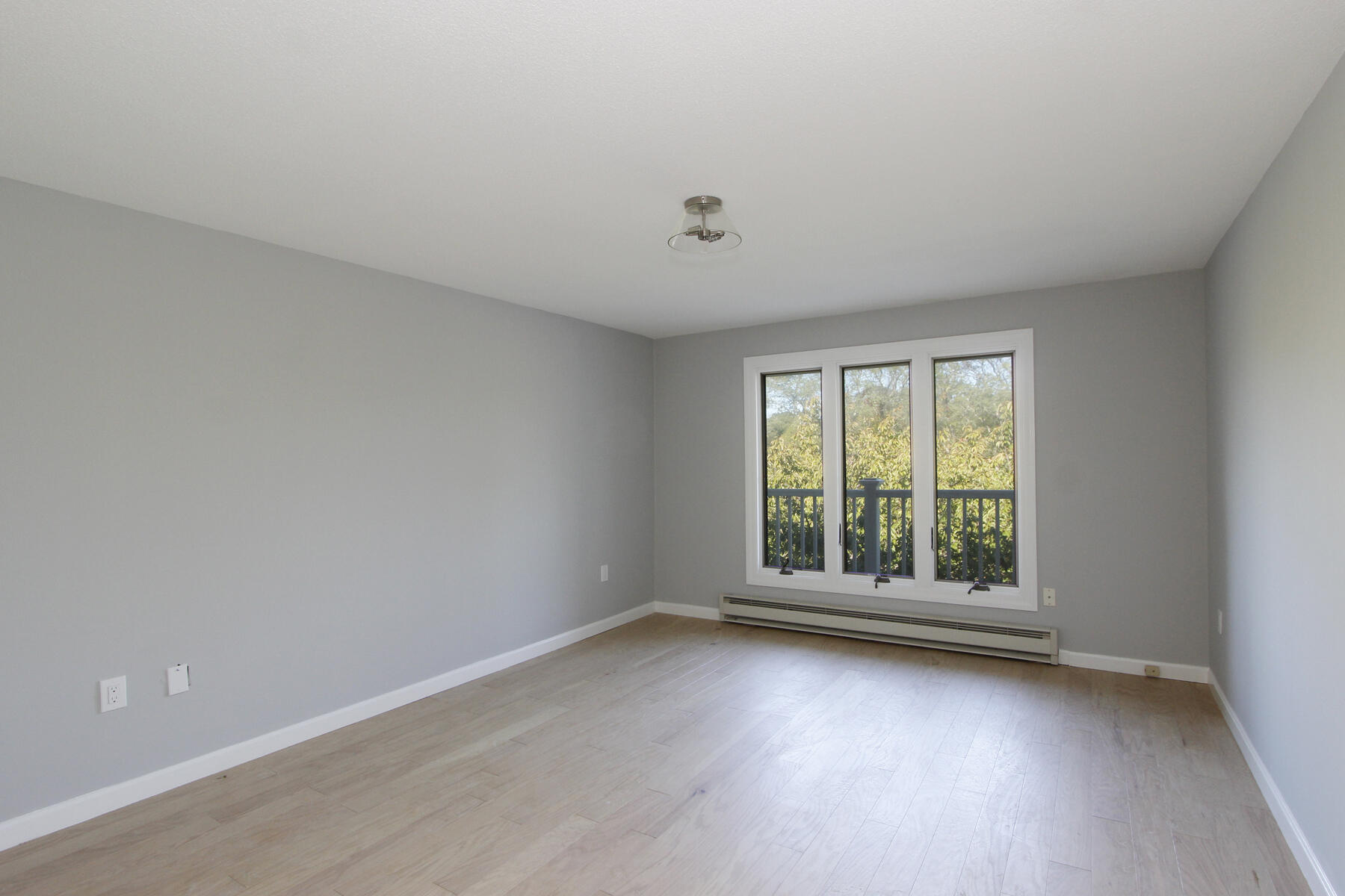 42 Old Colony Way, Unit 30 Orleans, MA 02653 - Photo 8 of 36 an empty room with wooden floor and windows