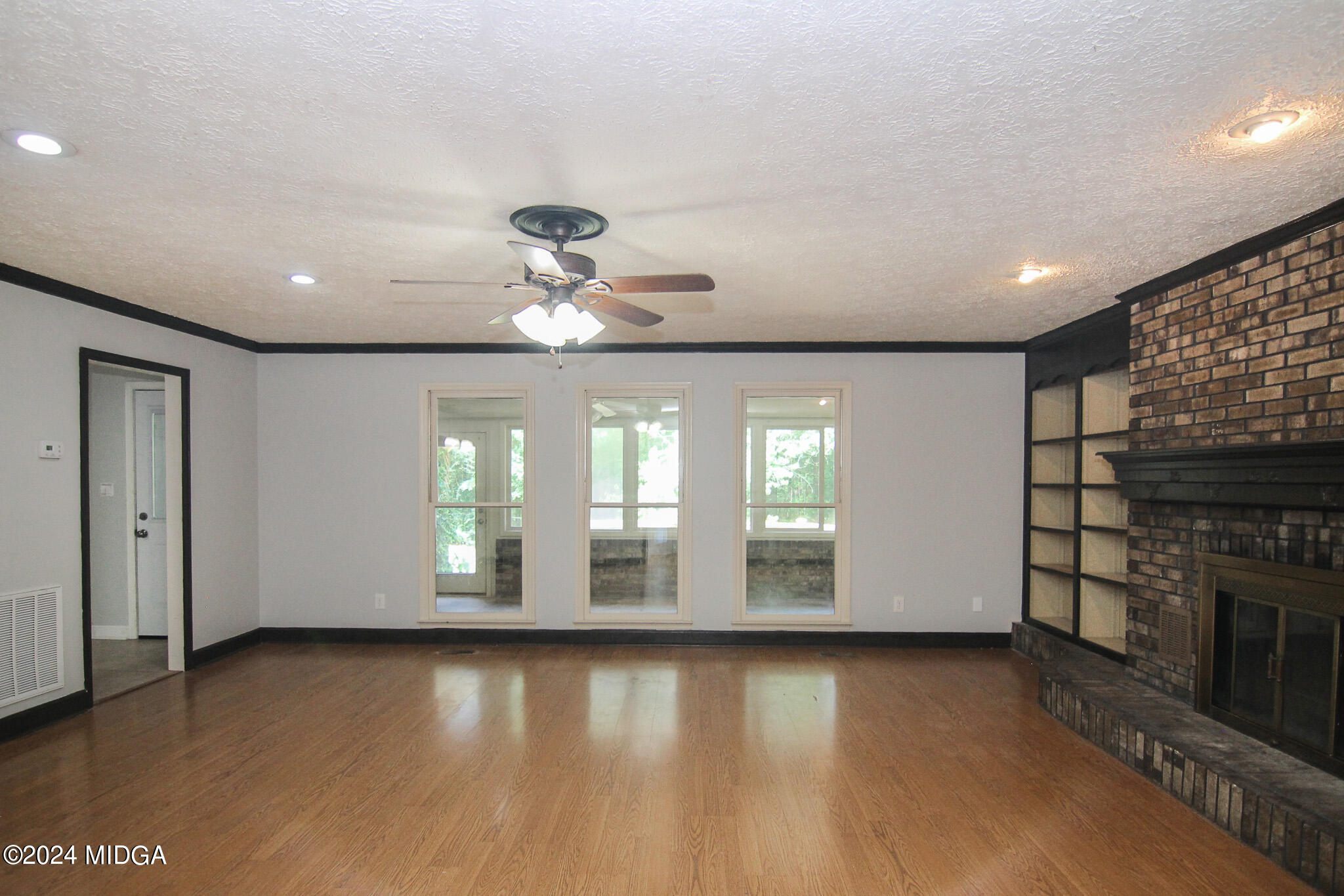 102 Nancy Place Bonaire, GA 31005 - Photo 4 of 48 an empty room with wooden floor and chandelier