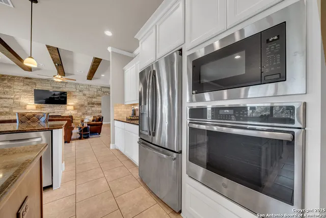 a kitchen with stainless steel appliances granite countertop a stove microwave and refrigerator