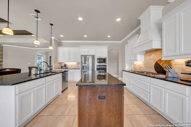 a large kitchen with kitchen island a sink a counter space and stainless steel appliances