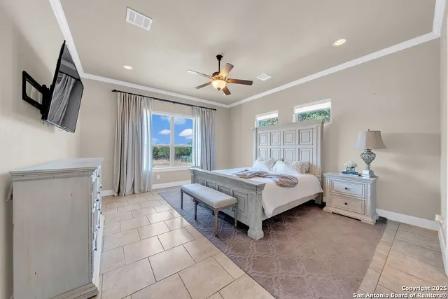 a spacious bedroom with a bed and a flat screen tv