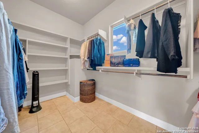 a view of walk in closet with clothes and shoes