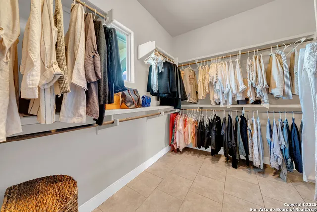 a view of walk in closet with clothes and shoes
