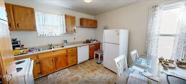 a kitchen with stainless steel appliances granite countertop a refrigerator sink and wooden floor