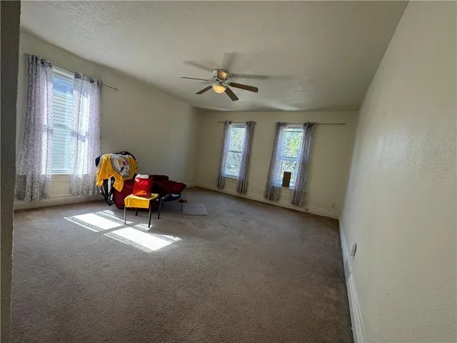 a living room with furniture a ceiling fan and a window