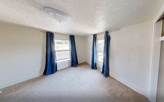 an empty room with windows and closet