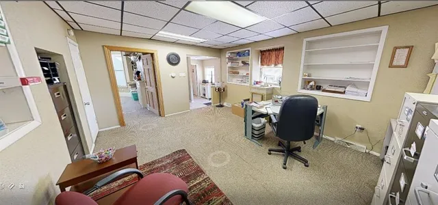 a view of a workspace with furniture and a window