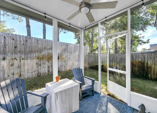 a view of a backyard with table and chairs and wooden fence