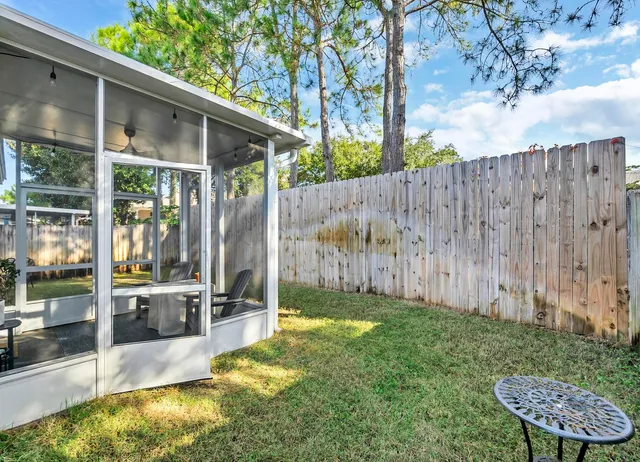a view of a backyard with wooden fence and a large tree