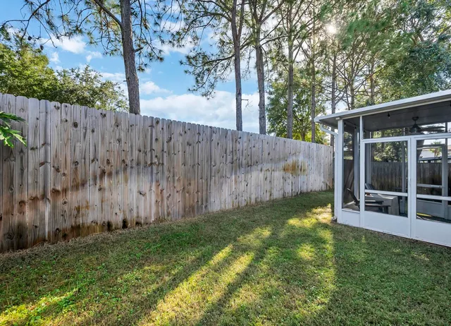 a view of a backyard with table and chairs and wooden fence