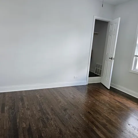 an empty room with wooden floor and closet