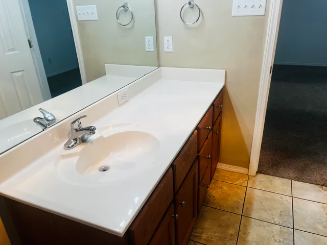 a bathroom with a granite countertop toilet and a sink