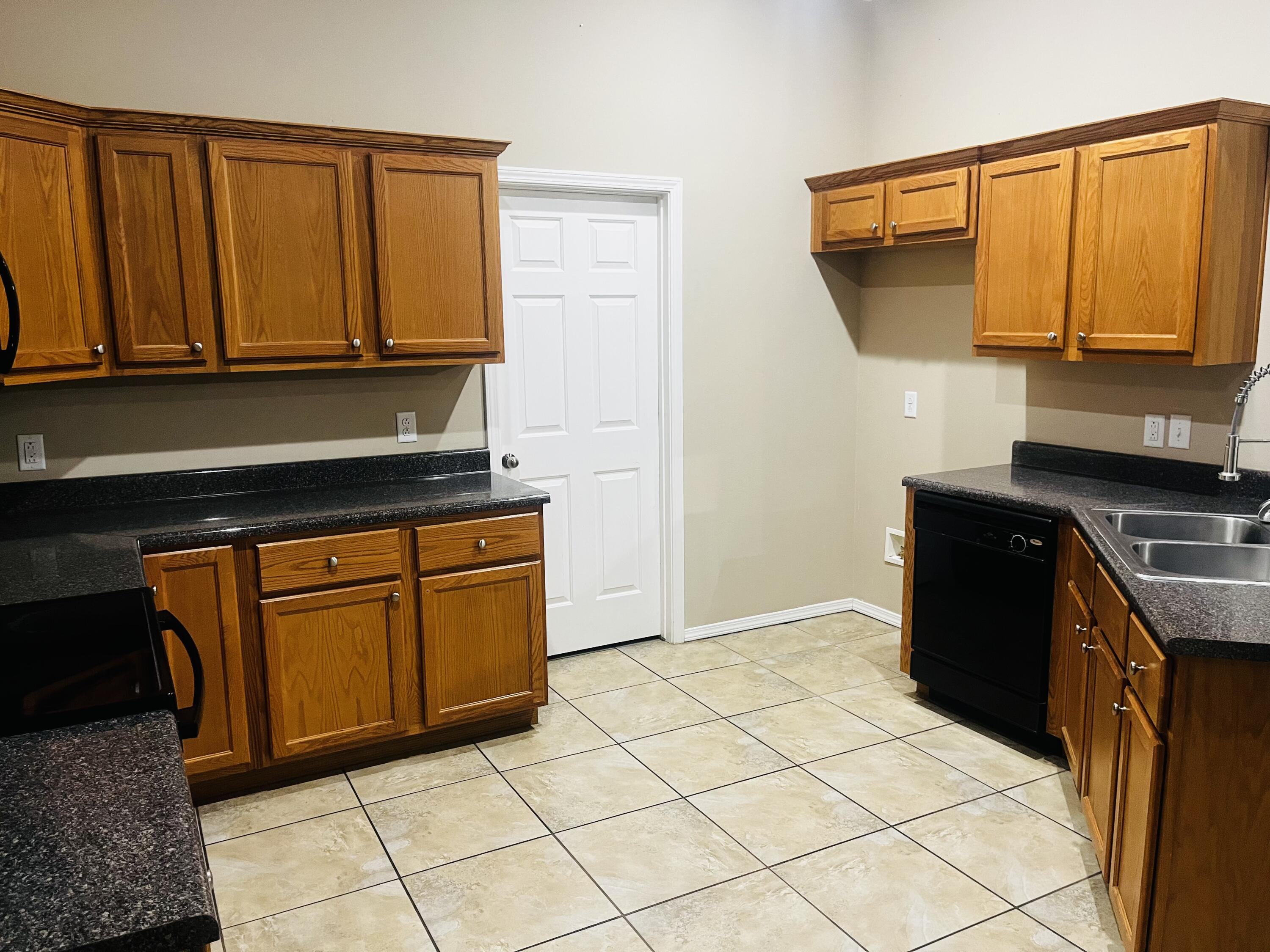 10016 Weatherford Avenue Lubbock, TX 79423 - Photo 2 of 29 a kitchen with granite countertop a stove a sink and dishwasher