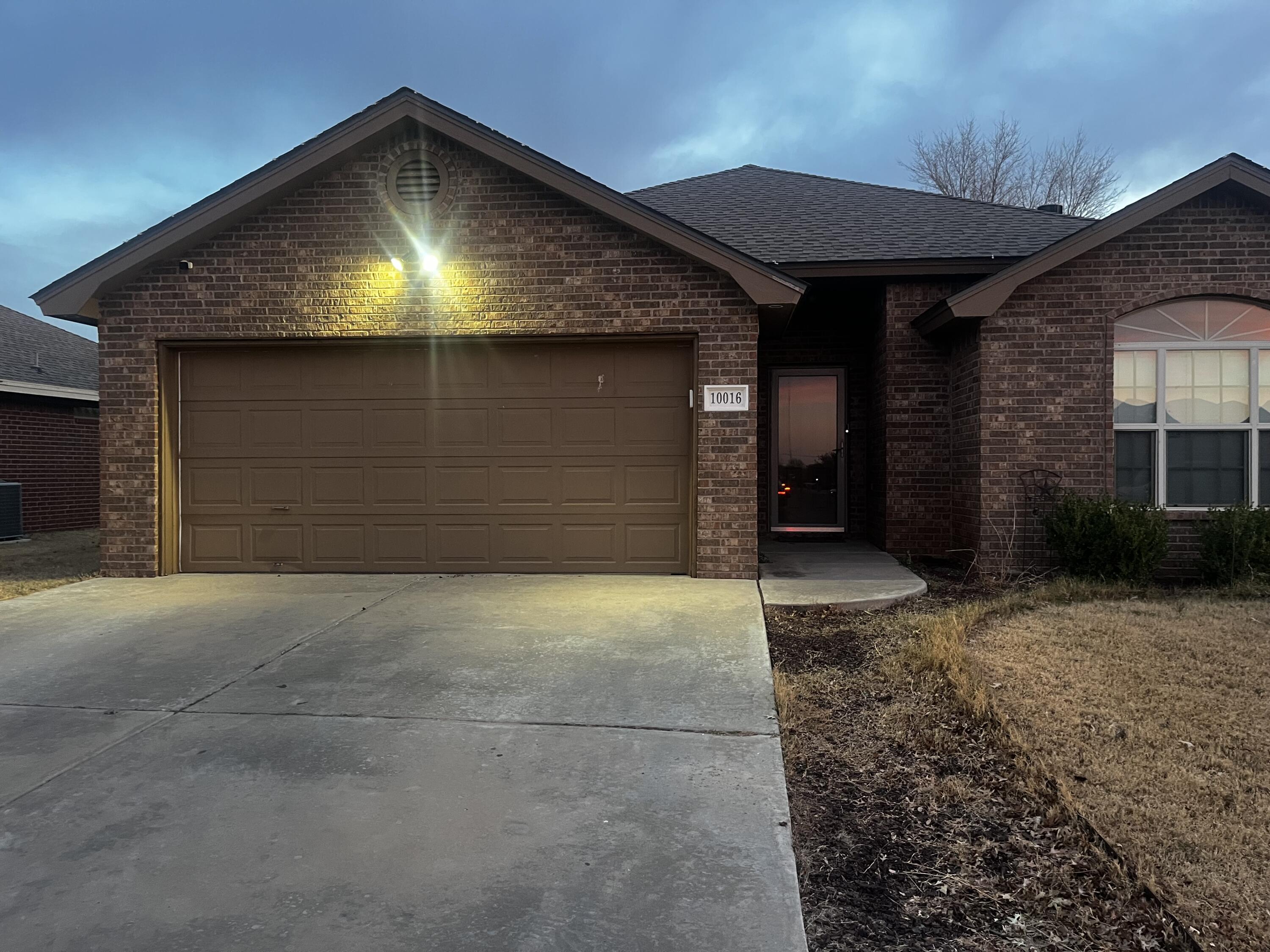 10016 Weatherford Avenue Lubbock, TX 79423 - Photo 26 of 29 a front view of a house with a yard and garage