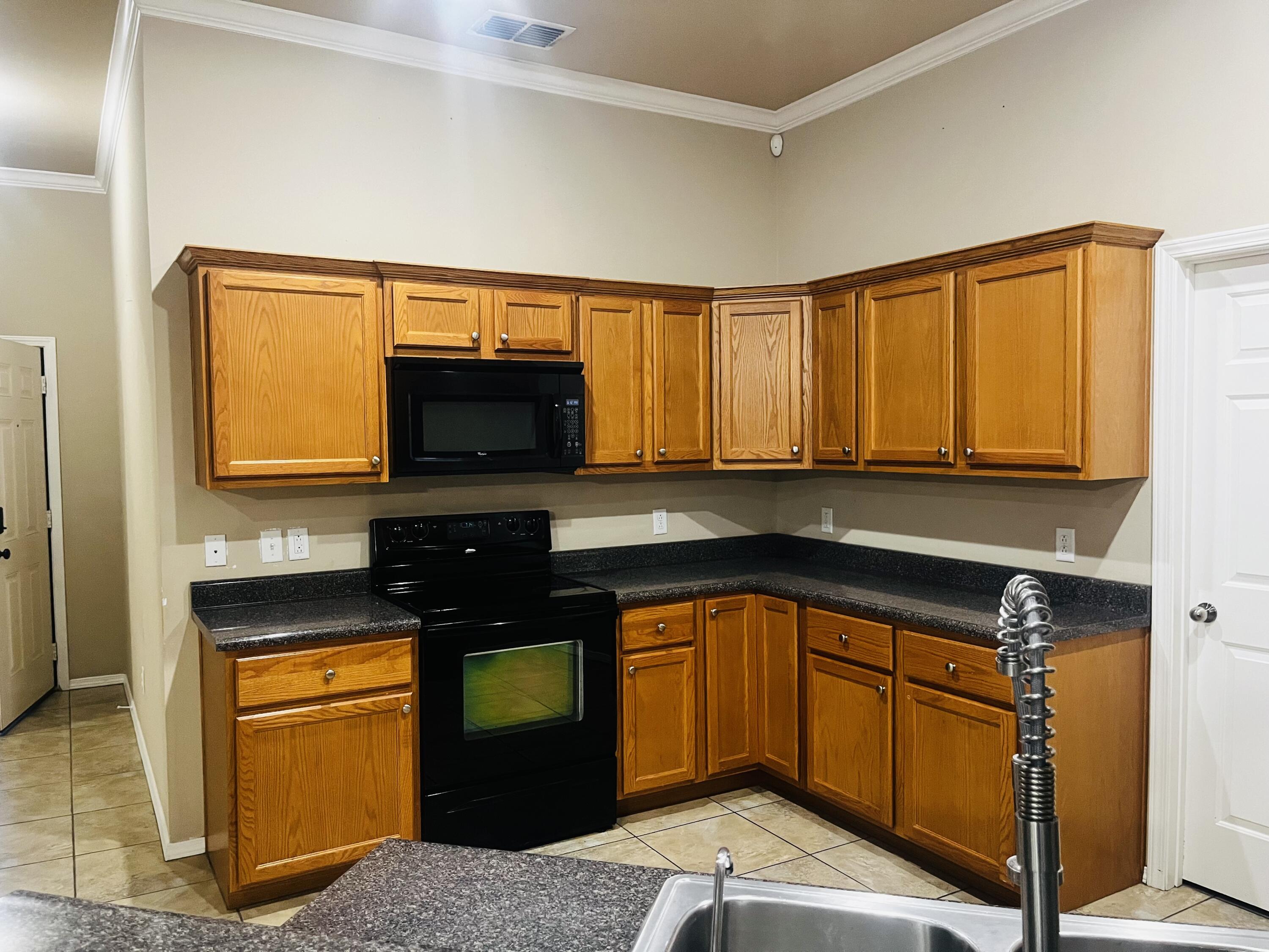 10016 Weatherford Avenue Lubbock, TX 79423 - Photo 4 of 29 a kitchen with stainless steel appliances granite countertop a sink stove and microwave