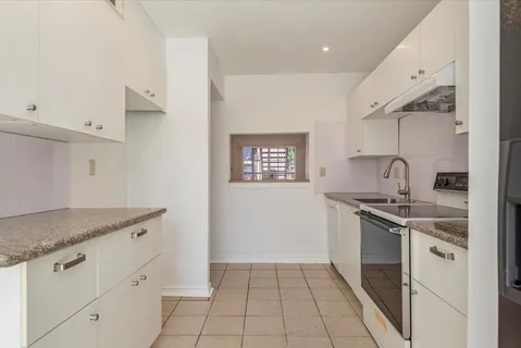 a kitchen with granite countertop a sink stove and cabinets