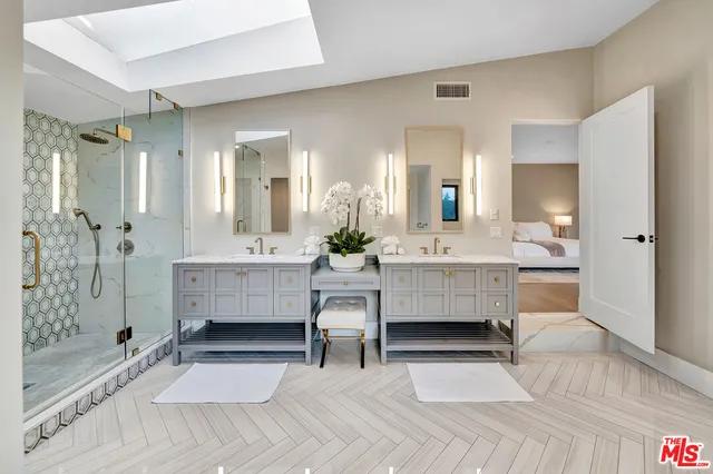 a bathroom with a double vanity sink mirror and shower