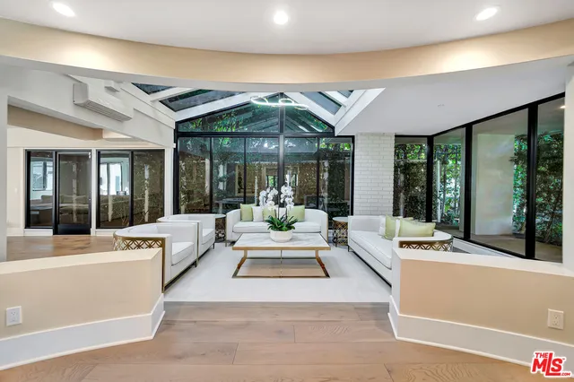 a living room with furniture and large windows