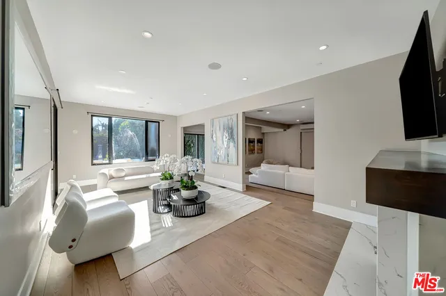 a living room with furniture large window and a flat screen tv