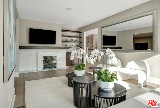 a living room with furniture a flat screen tv and a fireplace