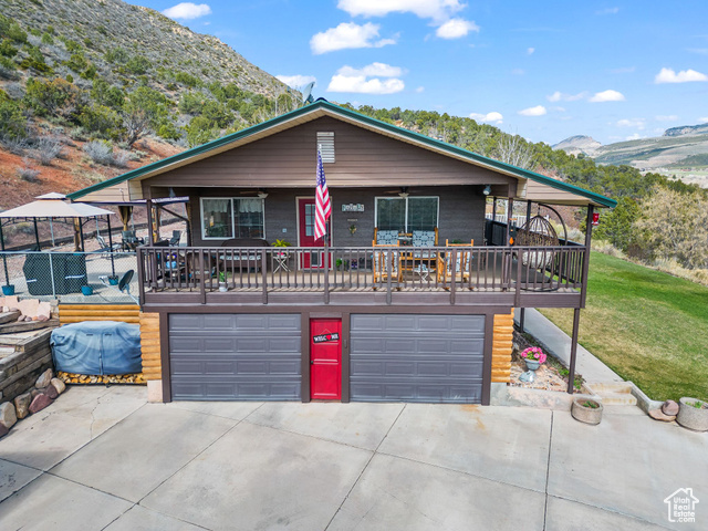 6407 North Dry Frk Cyn Road West Vernal, UT 84078 - Photo 7 of 48 View of front facade with a garage, a mountain view, driveway, ceiling fan, and a front lawn