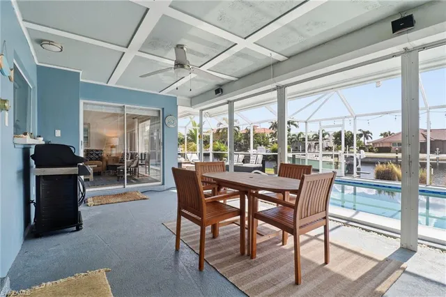 a dining room with furniture and a floor to ceiling window