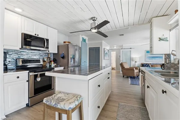 a kitchen with a sink stainless steel appliances and white cabinets