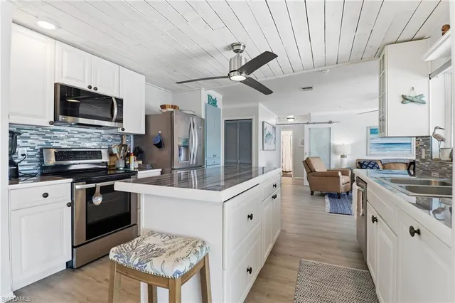 a kitchen with a sink stainless steel appliances and white cabinets
