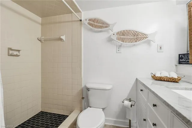 a bathroom with a granite countertop sink and a toilet