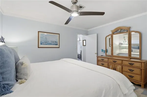a bedroom with a bed a mirror and a window