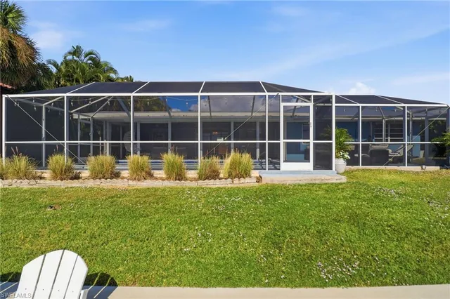 a view of a house with backyard and sitting area