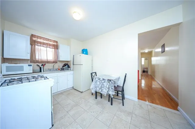 a kitchen with refrigerator and table chair