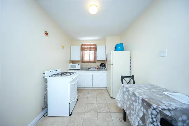 a kitchen with a refrigerator and white cabinets