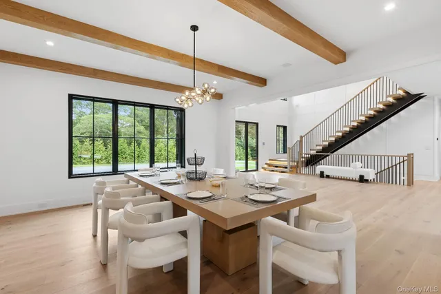 a view of a dining room and livingroom with furniture wooden floor a chandelier