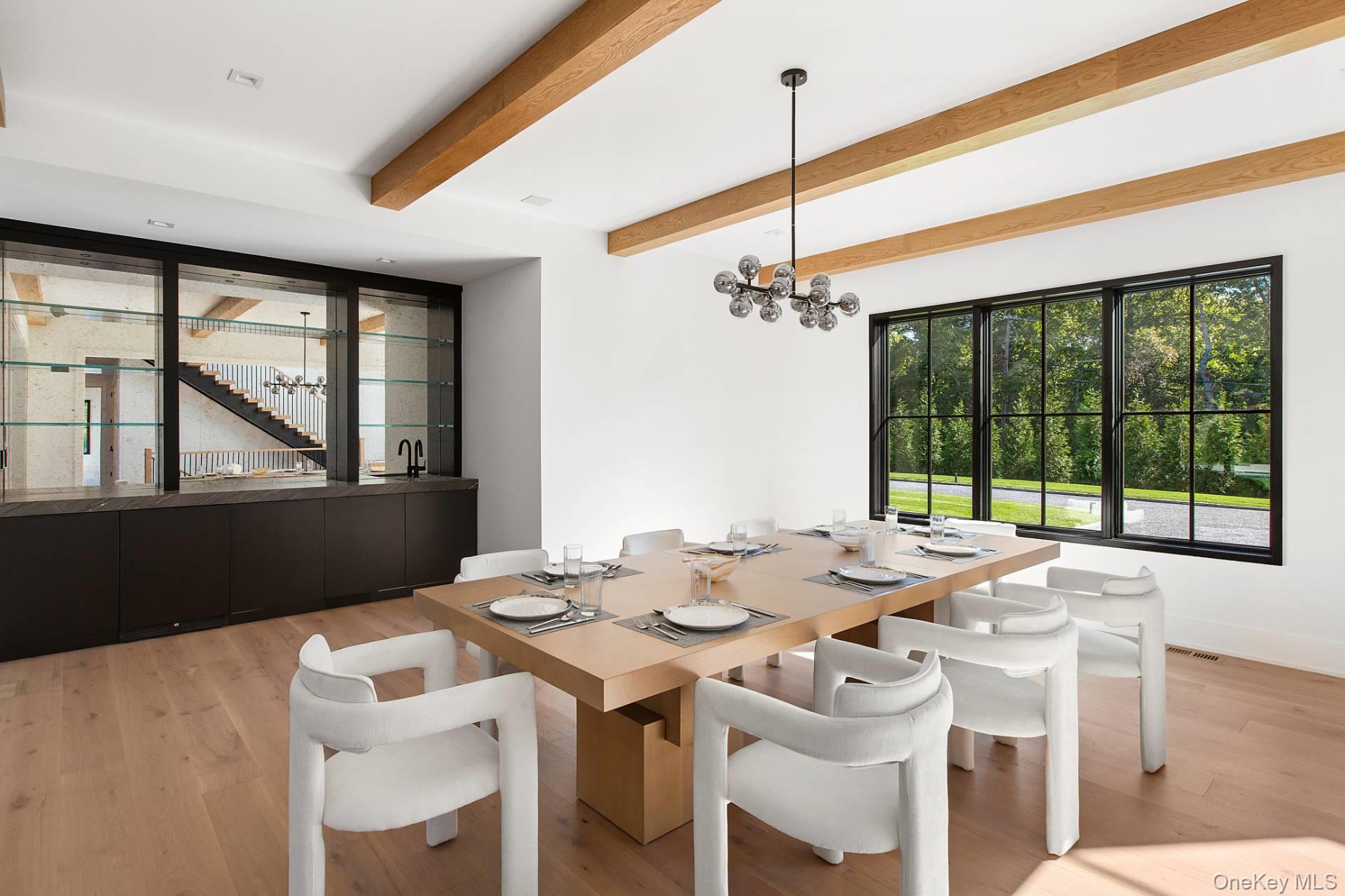 150 Edge Of Woods Road Southampton, NY 11968 - Photo 13 of 47 a view of a dining room with furniture large windows and wooden floor