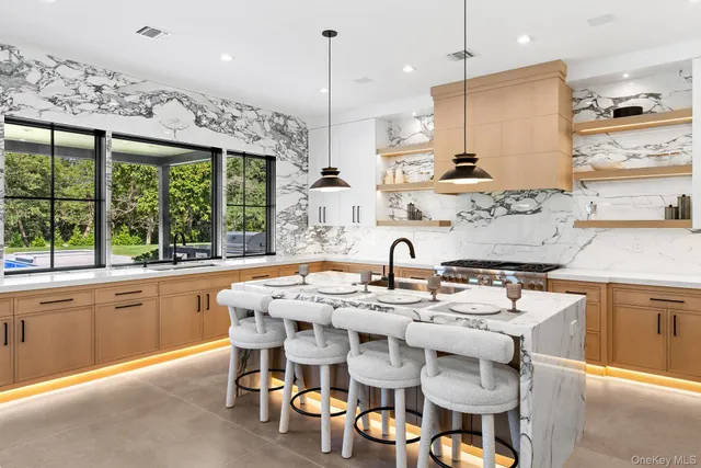 a dining table with chairs and kitchen view
