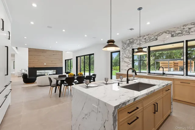a kitchen with sink stove and white cabinets with wooden floor