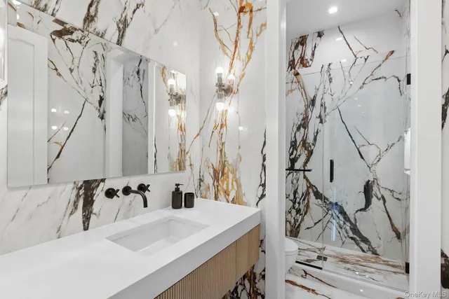 a bathroom with a sink and mirror with bathtub