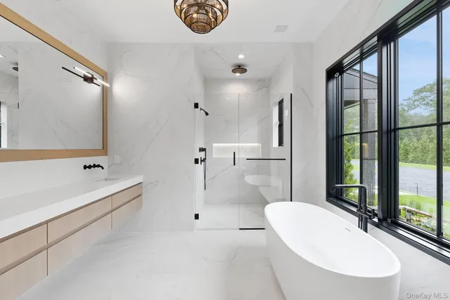 a bathroom with a tub sink and mirror