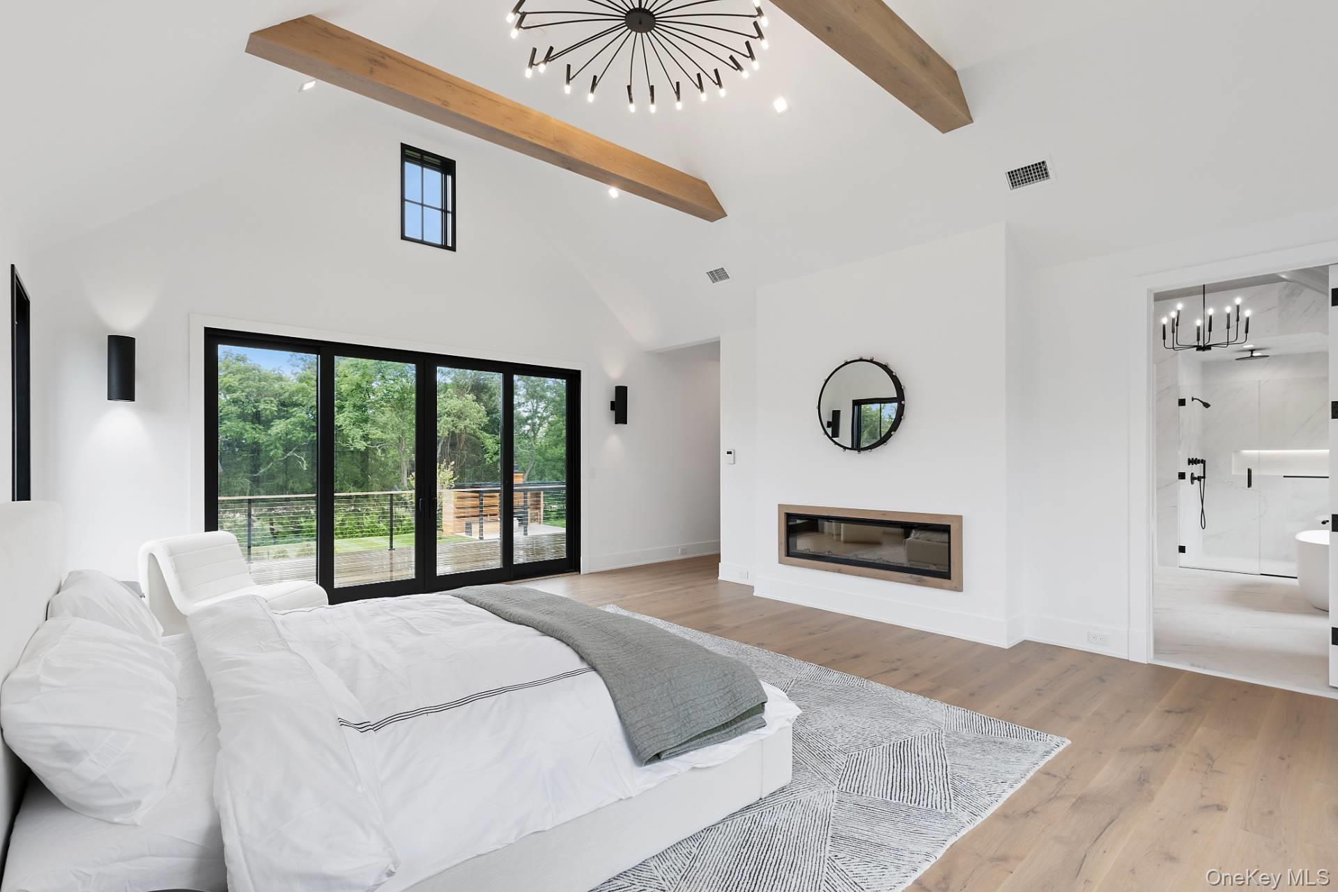 150 Edge Of Woods Road Southampton, NY 11968 - Photo 25 of 47 a bedroom with a bed and a large window